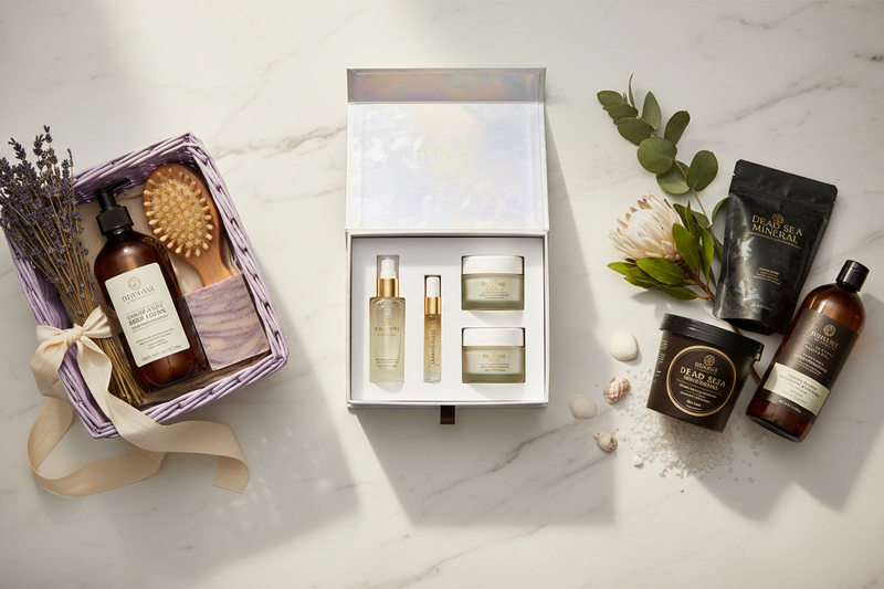 Luxury skincare gift sets for women — spa gift basket, bioactive skincare box and Dead Sea mineral set styled on marble with dried flowers and greenery