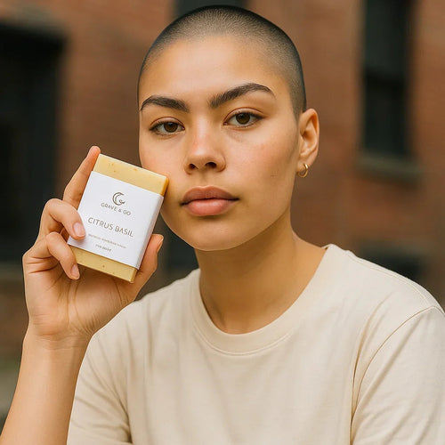 Person holding a bar of soap with a visible brand label against a blurred background