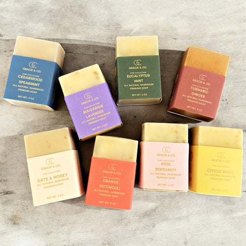 Assorted bars of soap in colorful packaging on a wooden surface