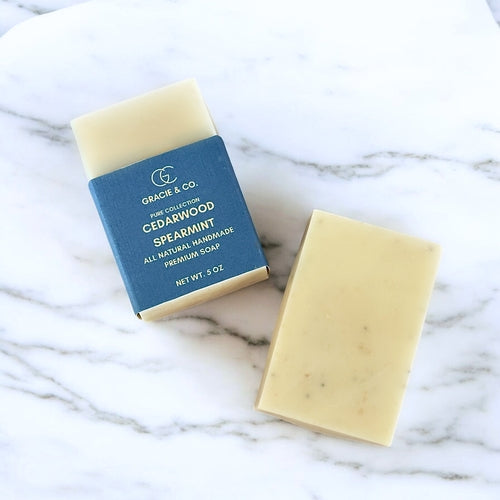 Two bars of soap, one with a blue label, on a marble surface