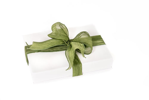 White gift box with a green ribbon on a white background