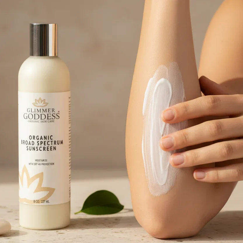Glimmer Goddess organic sunscreen bottle with a person applying it to their arm.